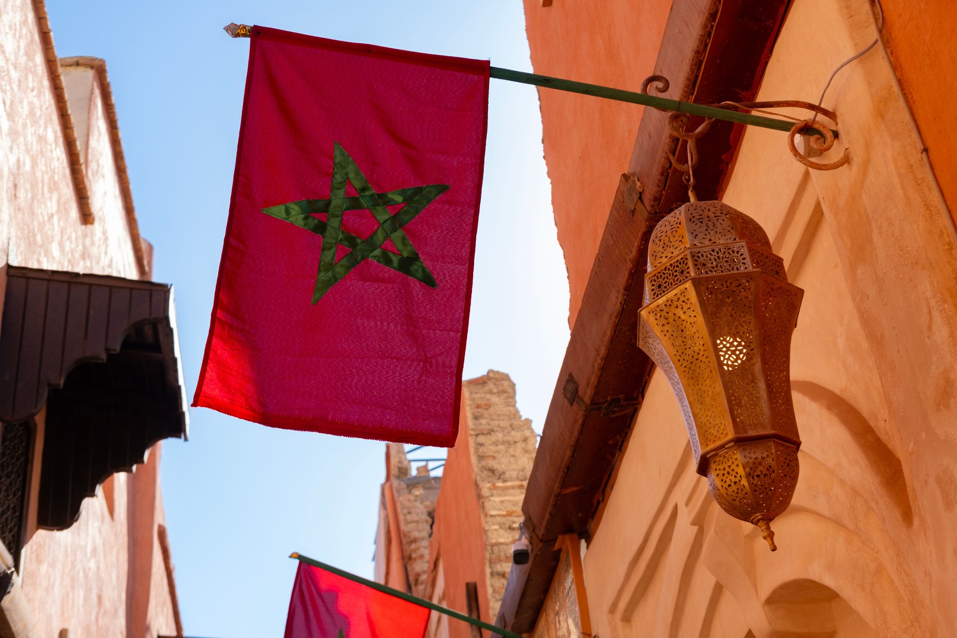 Red national Moroccan Flag flutters on silk against sky, Five-pointed star, government building, independence day, business and country's budget